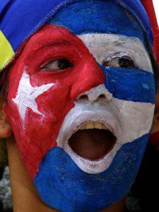 Una mujer con la cara pintada de la bandera cubana frente a la embajada de Cuba en Venezuela. / Juan Barreto (AFP)