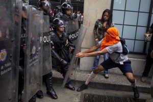 Protestors clash with police in Caracas in May. At least 43 people have died this year during anti-government rallies. Photographer: Miguel Gutierrez/Landov