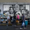 Fotografía que muestra personas caminando frente a vendedores informales de libros en Caracas (Venezuela). EFE/Miguel Gutierrez
